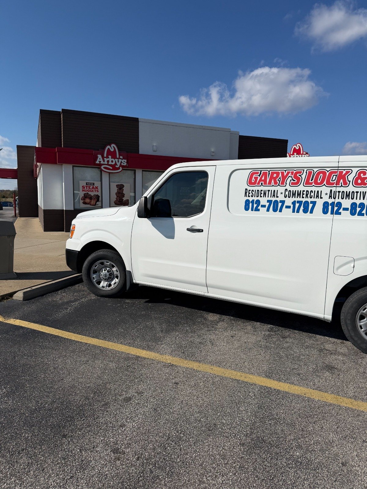 Commercial locksmith repairing a storefront door lock in Bedford